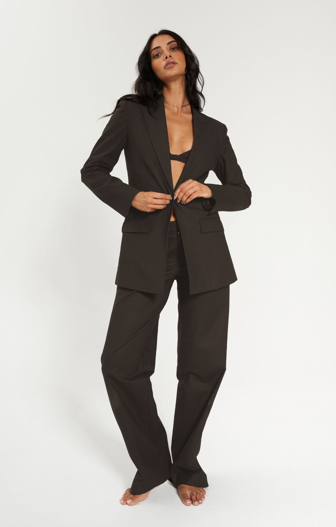Woman wearing a espresso suit on a white background