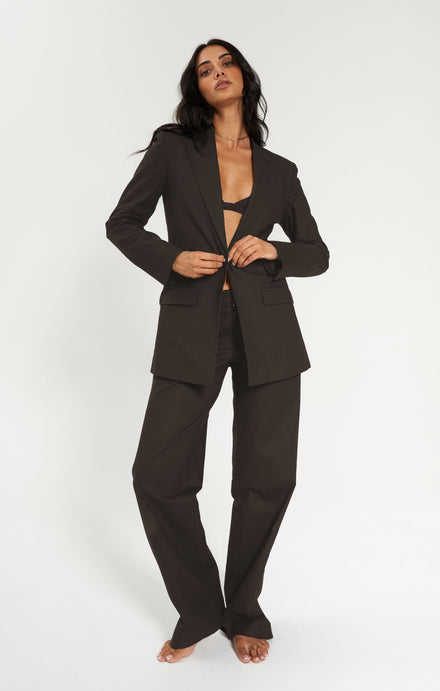Woman wearing a espresso suit on a white background